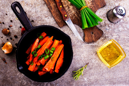 Fried carrots with green herbs in baking tray, close upの写真素材