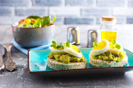 grain toast with avocado, white cheese and boiled egg, diet foodの写真素材