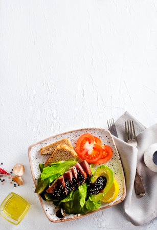 Cooked juicy tuna steak with vegetables on a plate. Restaurant food.の写真素材