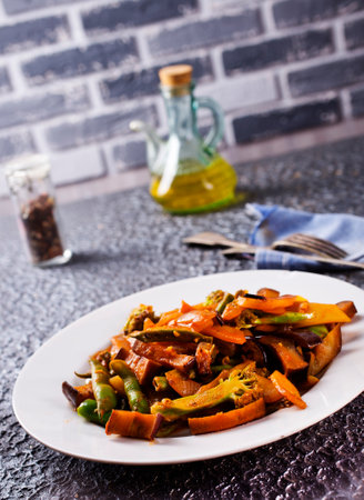 Chopped cooked vegetables on dark background, ratatouille with zucchini, bell pepper and eggplantの写真素材