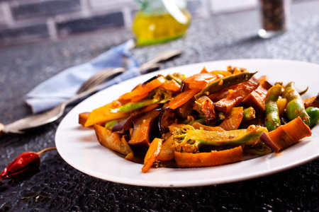 Chopped cooked vegetables on dark background, ratatouille with zucchini, bell pepper and eggplantの写真素材