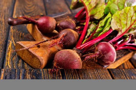 fresh beets on cutting board, set on wooden tableの写真素材