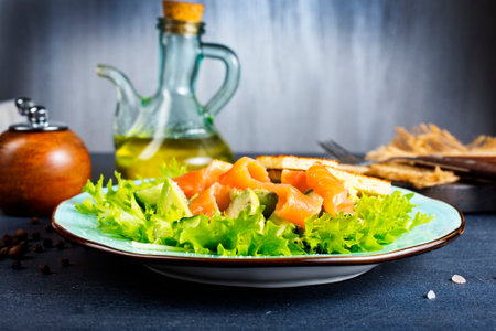 salad with fresh salmon, cucumber and olive oil on plateの写真素材