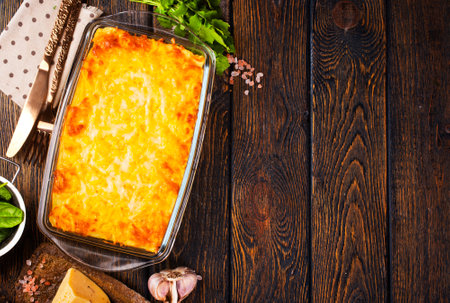 Rectangular glass bowl filled with mashed potato, underneath which is fish in cheese sauce.の写真素材