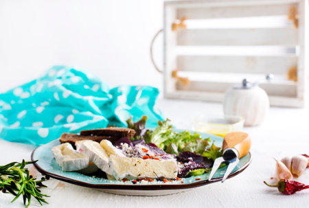 Greek salad with feta cheese and herbs on a white wooden backgroundの写真素材