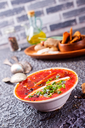 Traditional Ukrainian Russian borscht. Bowl of red beet root soup borsch with lard and dark bread on a tableの写真素材
