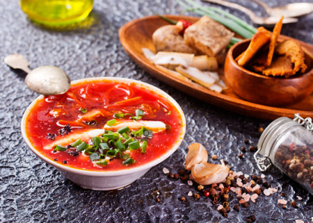 Traditional Ukrainian Russian borscht. Bowl of red beet root soup borsch with lard and dark bread on a tableの写真素材
