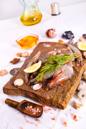 raw shrimps with salt and spice on stone boardの写真素材