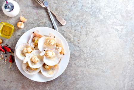 Fresh appetizing scallops with shells served on white plateの写真素材