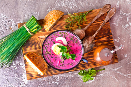 A portion of beetroot soup with egg, dill, parsley and cucumber on a gray background. Top view, copy space.の写真素材
