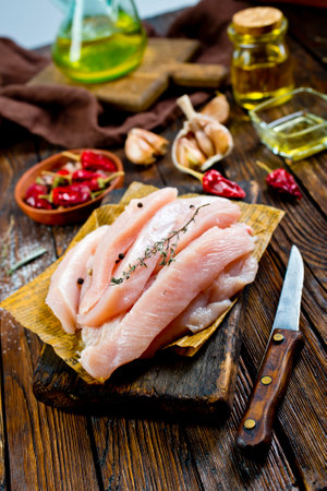 raw chicken meat, chicken fillet with spice on boardの写真素材