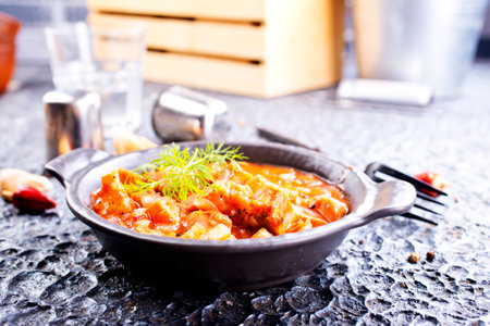 fried meat with tomato sauce and vegetables in bowlの写真素材