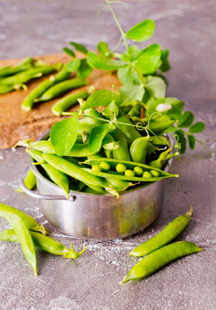 Green peas in metal bowl on a tableの写真素材