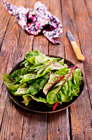 Fresh salad leaves. Raw green leaf vegetables. Mangold leaves on plateの写真素材