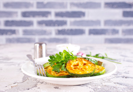 Heap of fried green zucchini with garlic on plateの写真素材