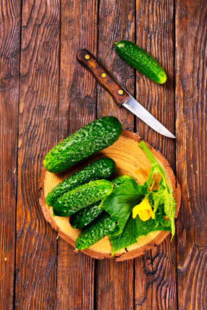 fresh cucumbers on board on wooden tableの写真素材