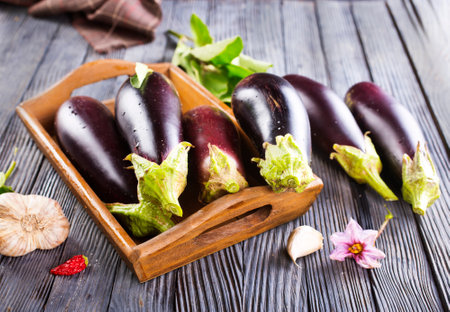 Raw eggplants (aubergines) in wooden box. Selective focus, top view,の写真素材