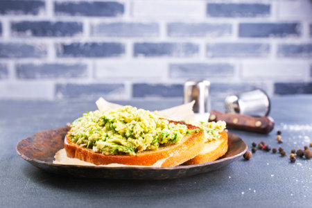 Traditional Mexican sauce guacamole on bread. Avocado cream on breadの写真素材