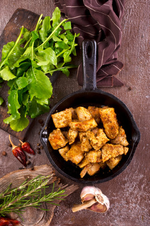 fried meat with spice in pan on a tableの写真素材