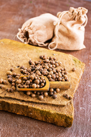 Pile of Black peppercorns (Black pepper) seeds on stone boardの写真素材
