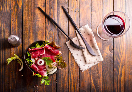 Sliced Pastrami roasted beef meat with vegetables. Wooden backgroundの写真素材