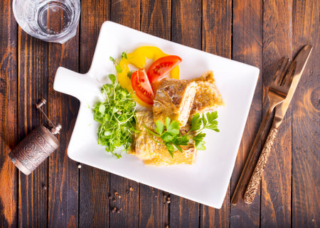 Japanese cuisine. National Japanese dish Omelet tamago yaki for breakfast. Rolled egg with spinach, tomato and cheese on a wooden table.の写真素材