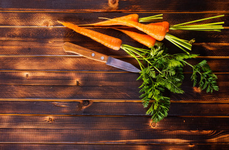 Orange and yellow carrots on a wooden background.の写真素材