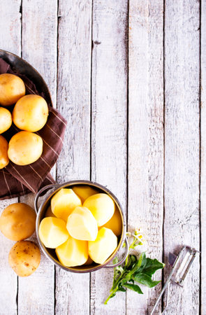Potatoes. Bowl with young raw potatoes on wooden backgroundの写真素材