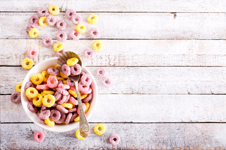 Bowl and plate of colorful cereal rings on light grunge backgroundの写真素材
