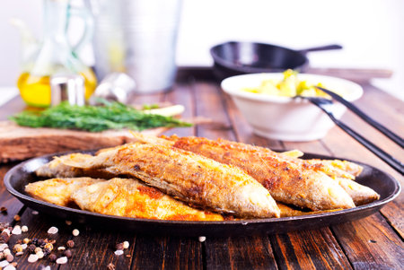Fried fish in flour and oil on metal plateの写真素材