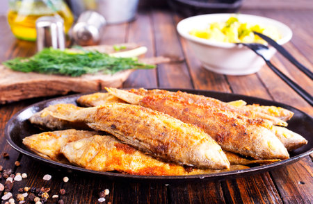 Fried fish in flour and oil on metal plateの写真素材
