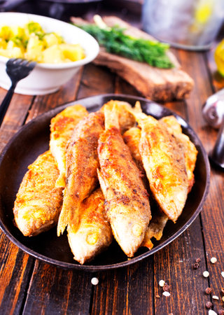 Fried fish in flour and oil on metal plateの写真素材