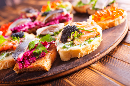 Cocktail canapes with herring, cream cheese and caviar on rye bread - gourmet party food.の写真素材