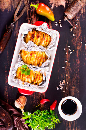 Baked potato with meat and cheese on dark table, top viewの写真素材