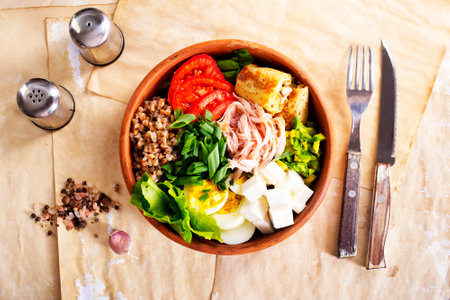 Delicious healthy breakfasts, buckwheat with boiled egg and meat and cheese on plateの写真素材