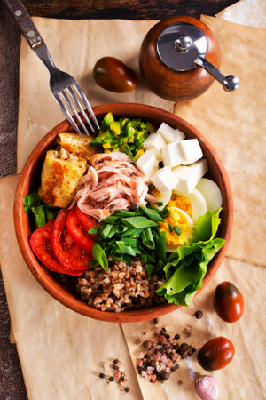 Delicious healthy breakfasts, buckwheat with boiled egg and meat and cheese on plateの写真素材