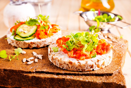 Fresh whole wheat sandwiches with smoked salmon on a wooden tableの写真素材