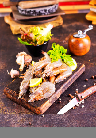 Shrimps Prawns skewers with herbs, garlic and lemon on a tableの写真素材