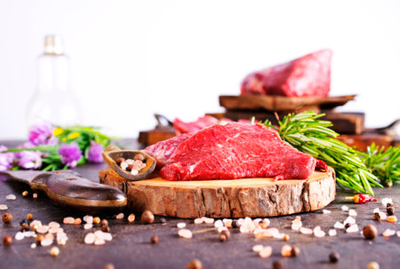Board with fresh raw steak meat on wooden tableの写真素材