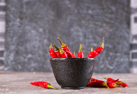 bowl with chilli pepper on gray tableの写真素材