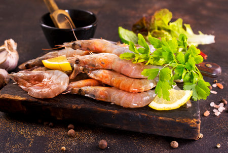 Shrimps Prawns skewers with herbs, garlic and lemon on a tableの写真素材