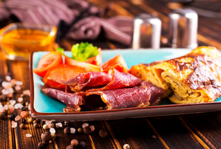 omelet with smoked meat, tomato and spice on plateの写真素材