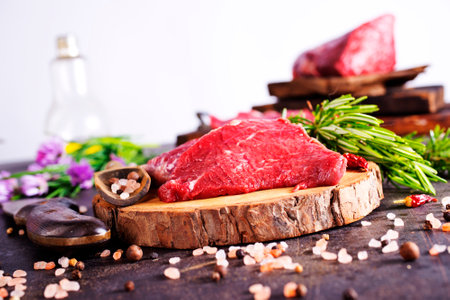 Board with fresh raw steak meat on wooden tableの写真素材