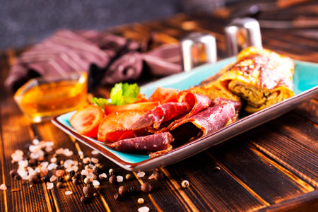 omelet with smoked meat, tomato and spice on plateの写真素材
