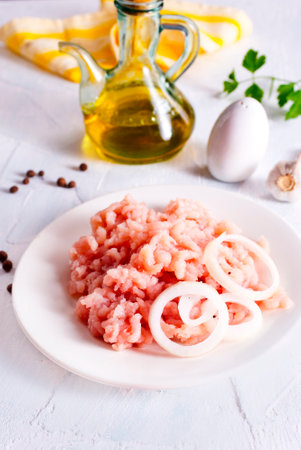 Fresh Minced Meat with herbs and onion on wooden tableの写真素材