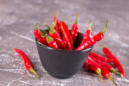 bowl with chilli pepper on gray tableの写真素材