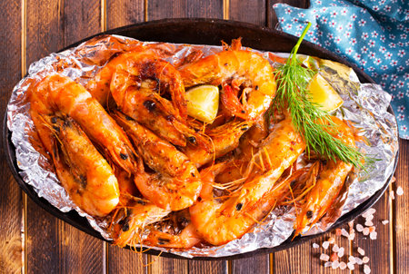Roast Prawns Shrimps in a pan with herbs and garlic. Dark wooden background. Top viewの写真素材