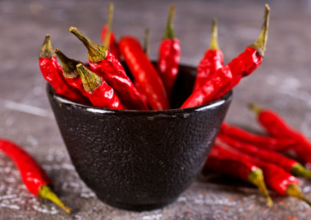 bowl with chilli pepper on gray tableの写真素材
