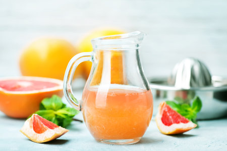 juice and fresh grapefruit on a tableの写真素材