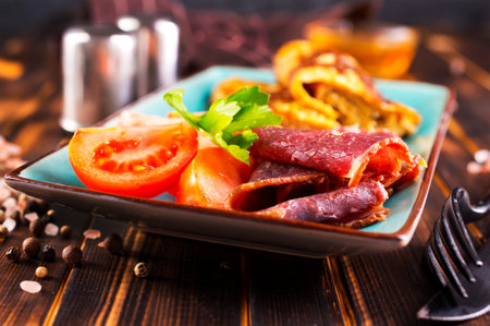 omelet with smoked meat, tomato and spice on plateの写真素材